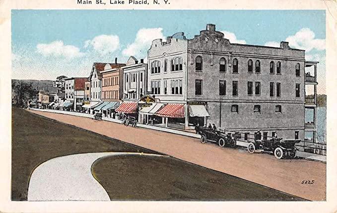 An old postcard shows Lake Placid, NY's Main Street, complete with 1920s-era automobiles.