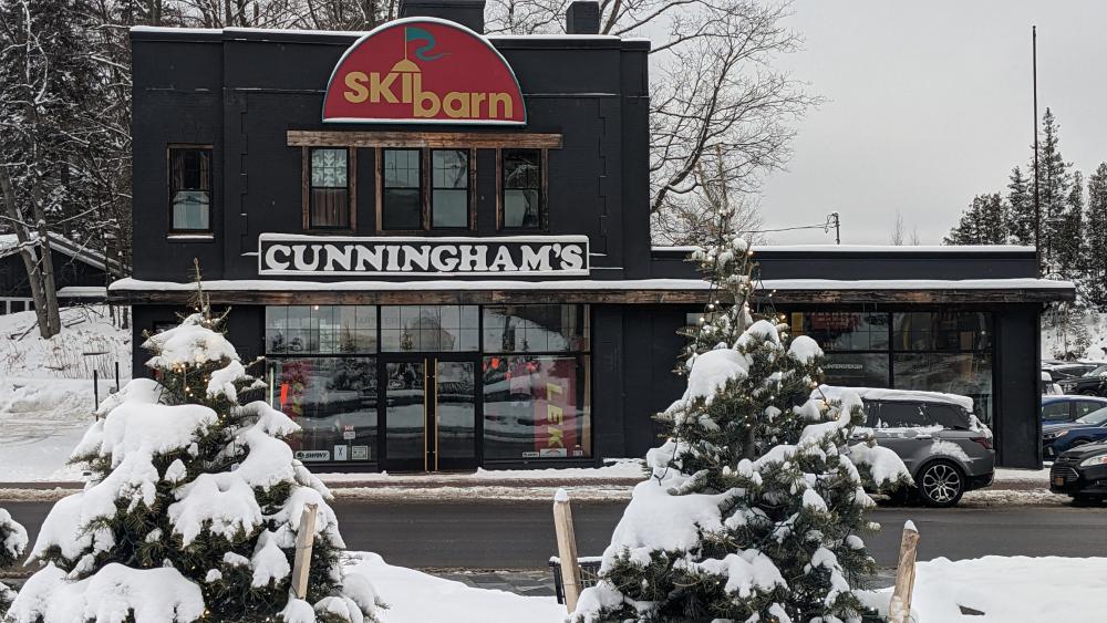 A ski shop is surrounded by snow-capped trees.