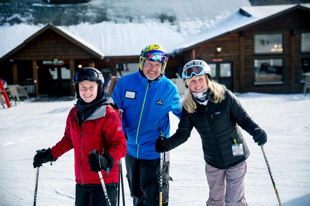 Three people posing after a ski lesson.