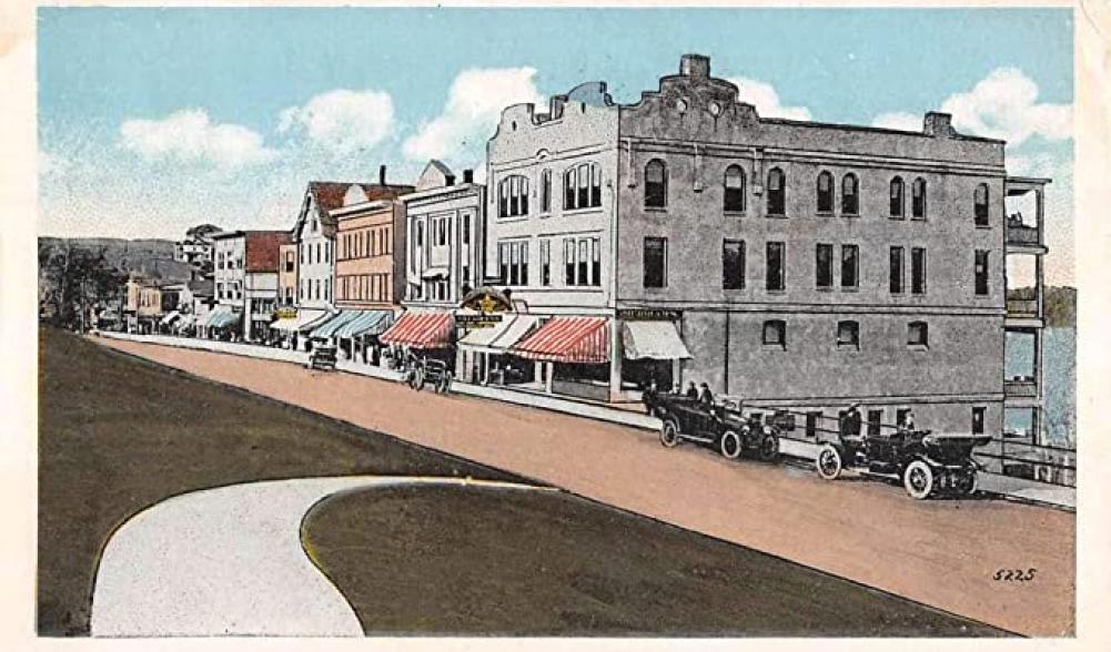An old postcard shows Lake Placid, NY's Main Street, complete with 1920s-era automobiles.