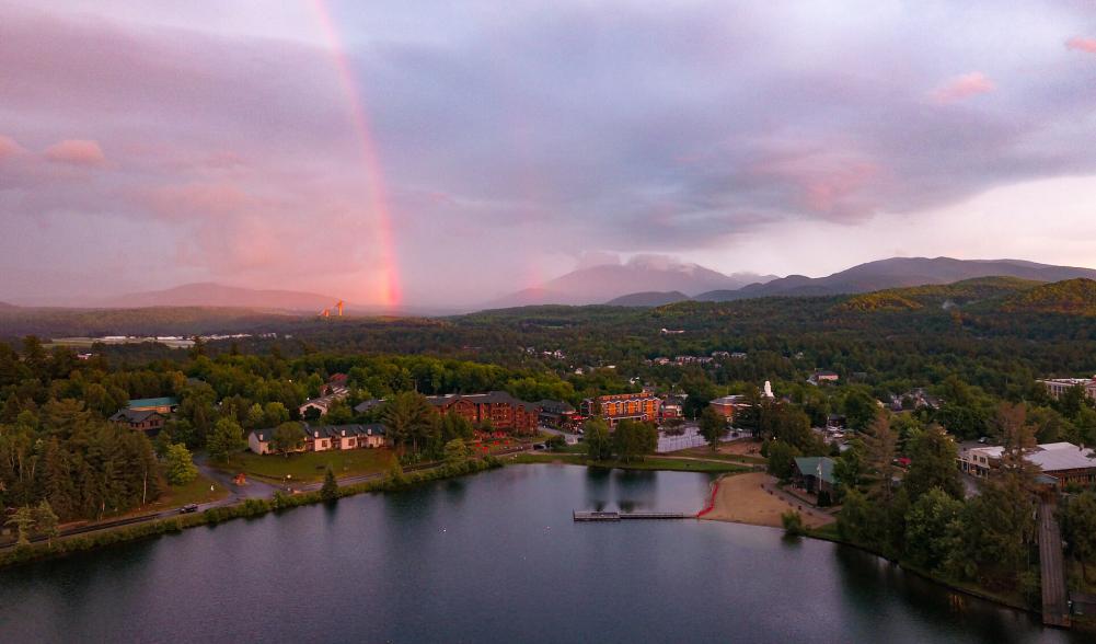 An aerial shot of Lake Placid, hotels, the ski jump and a rainbow.