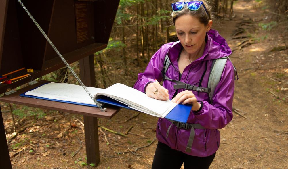 A hiker registers at trailhead