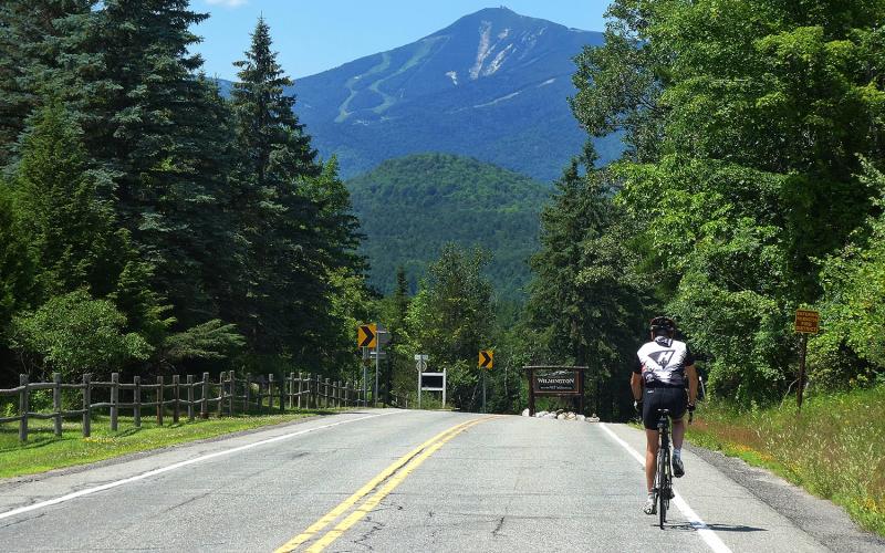 Cyclist on road with Whiteface Mountain in distance