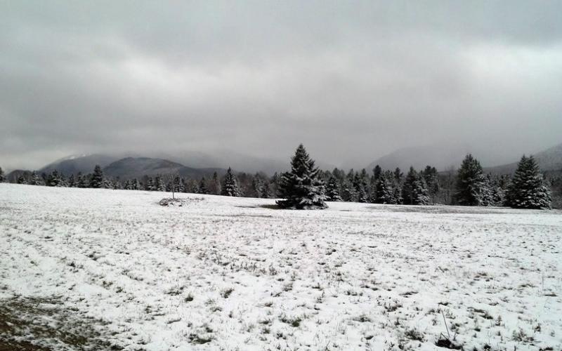 A wintry view of a field and mountains