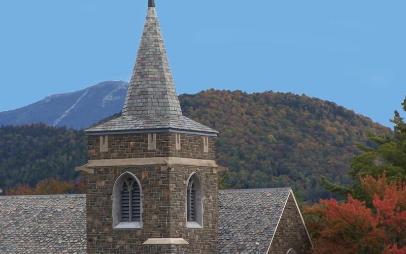 A church with mountains in the background during fall