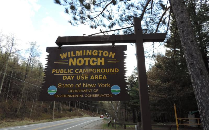 A brown and yellow wooden sign for Wilmington Notch.