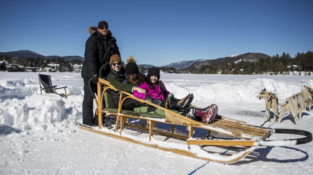Family smiles as they wait for their dog sled ride to start