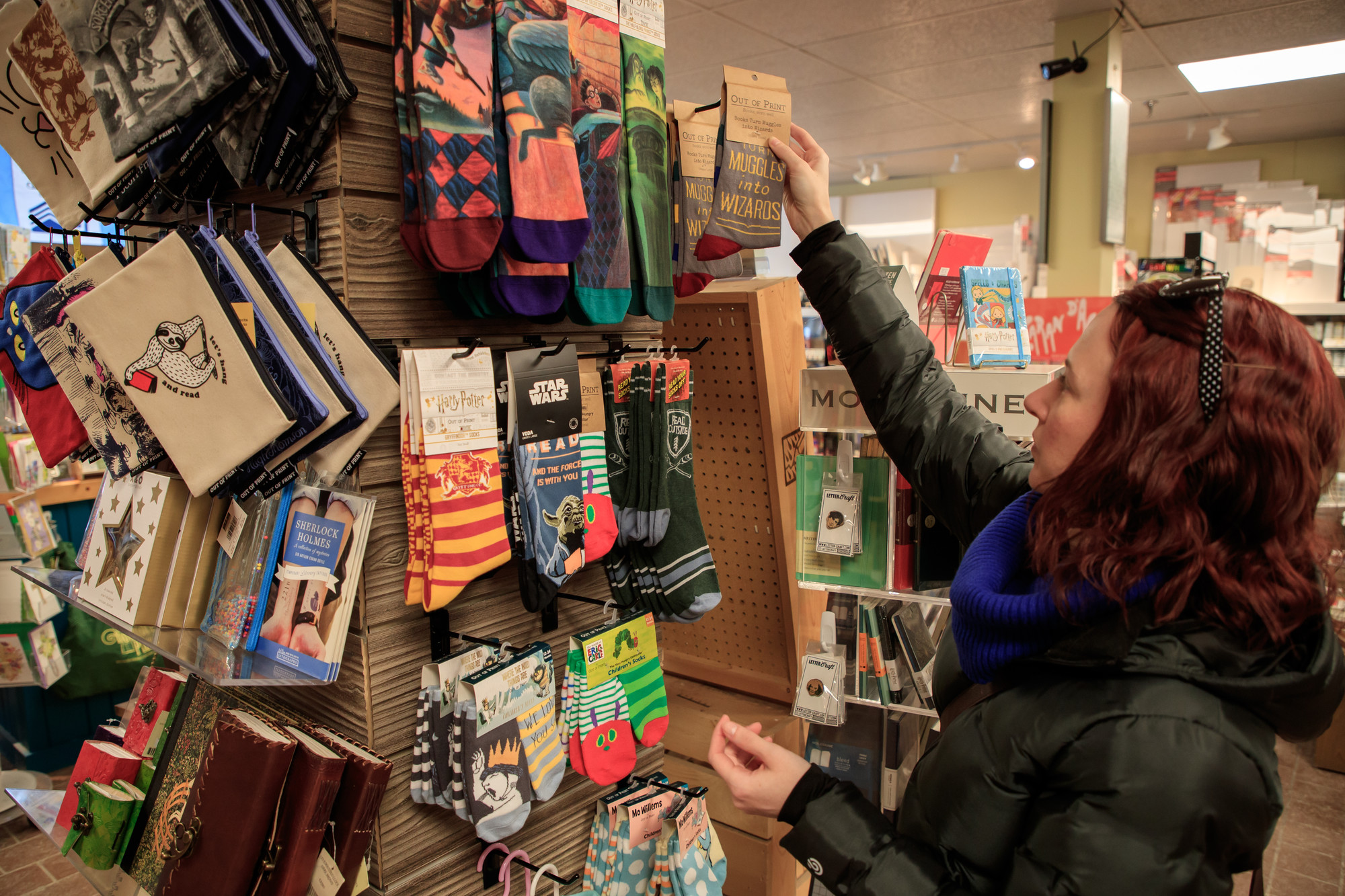 A woman shops for colorful socks in a shop.