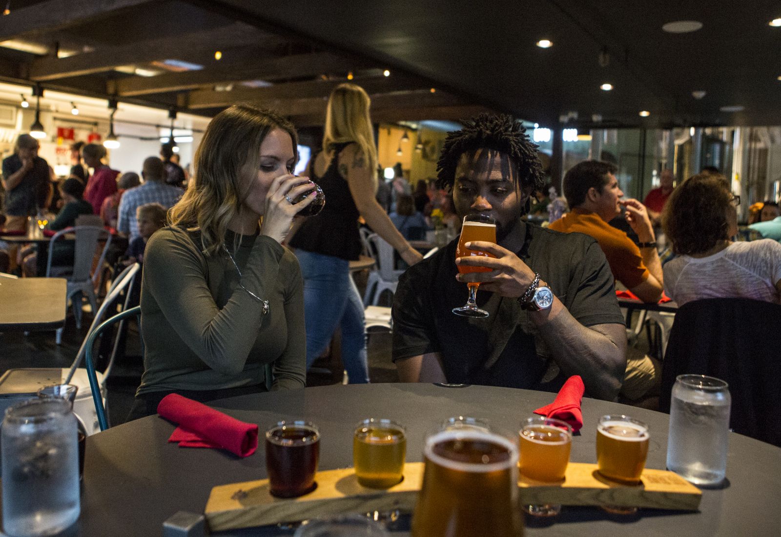 A man and woman sample beer in a busy Adirondack pub.