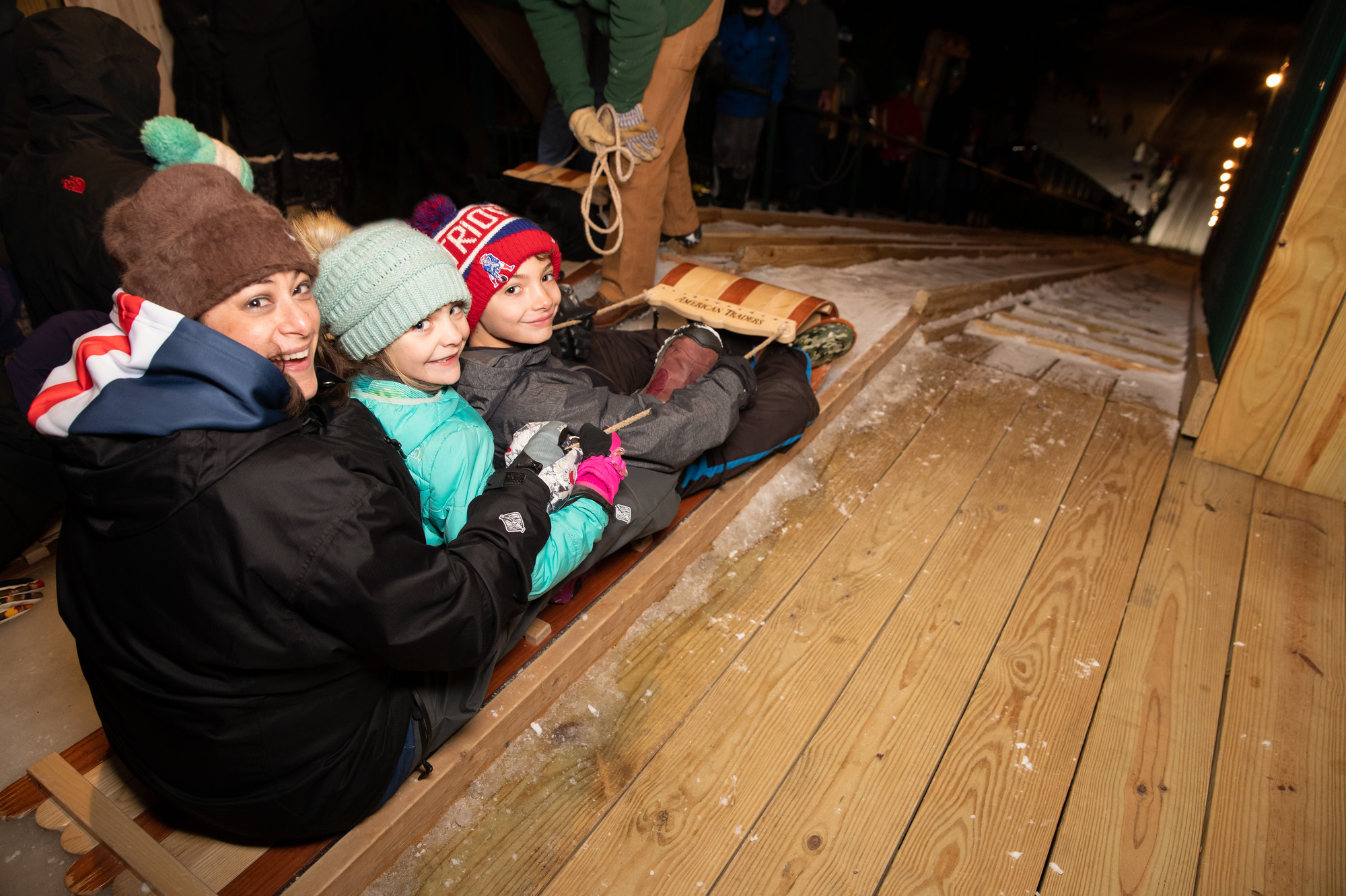A woman and two children prepare to slide down the toboggan chute.