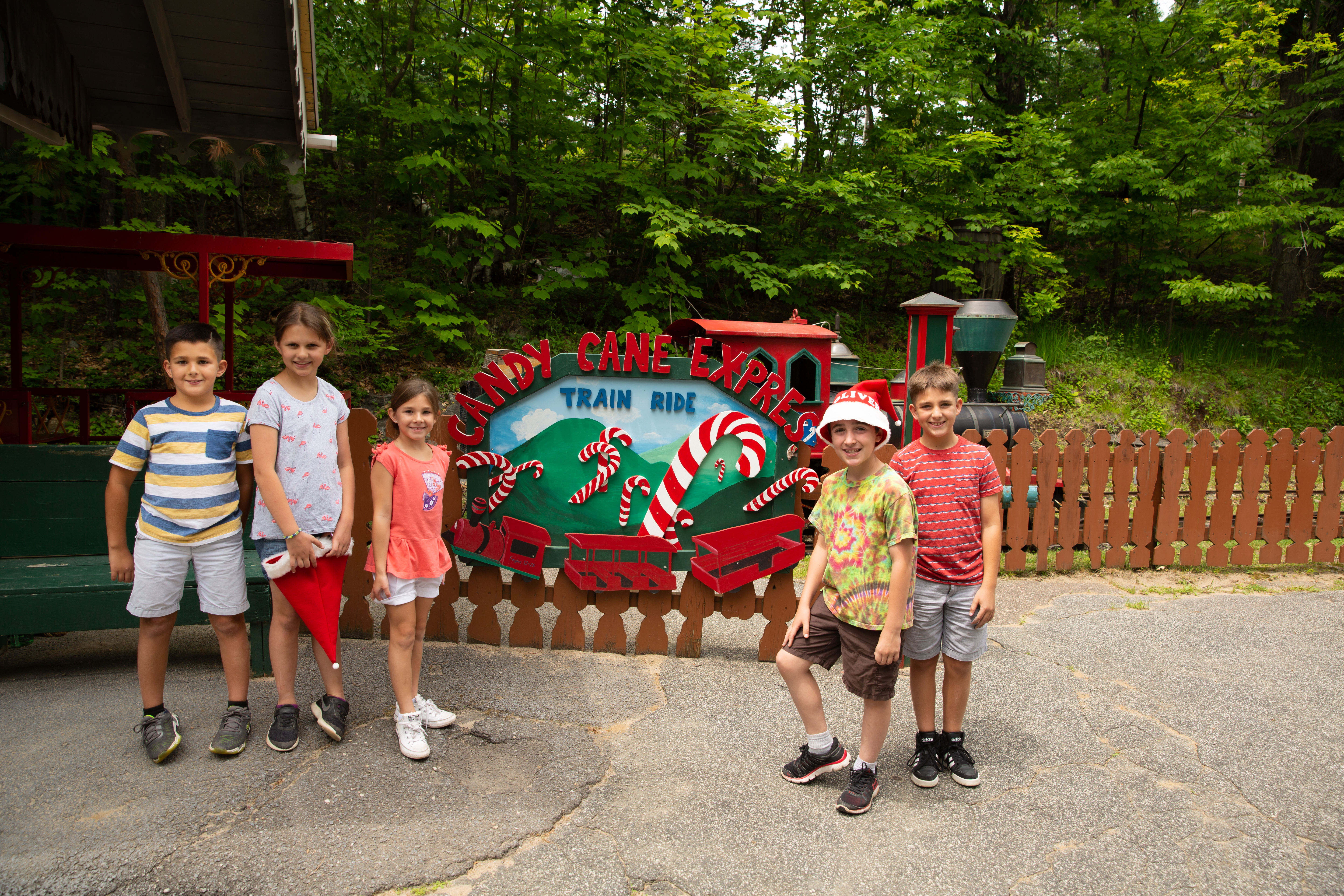 Five children standing in front of a Candy Cane Express Train Ride sign at Santa's Workshop.