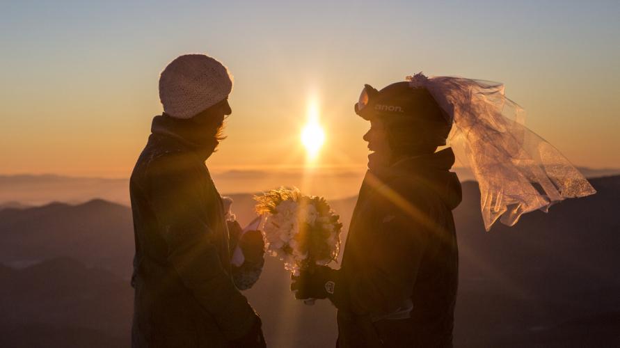 Two women marry in a sunrise ceremony on a mountaintop in winter.