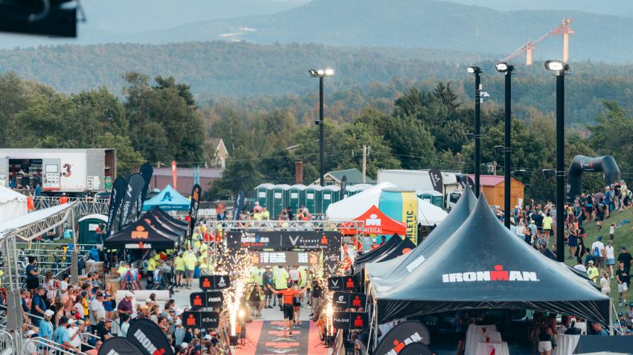 A large crowd watches athletes finish a race