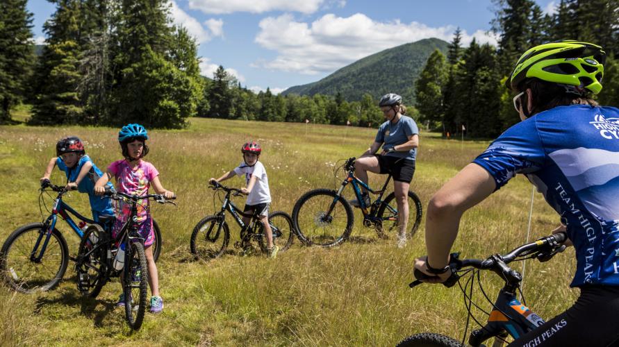 Adult and child mountain bikers on a flat trail in the Adirondacks.
