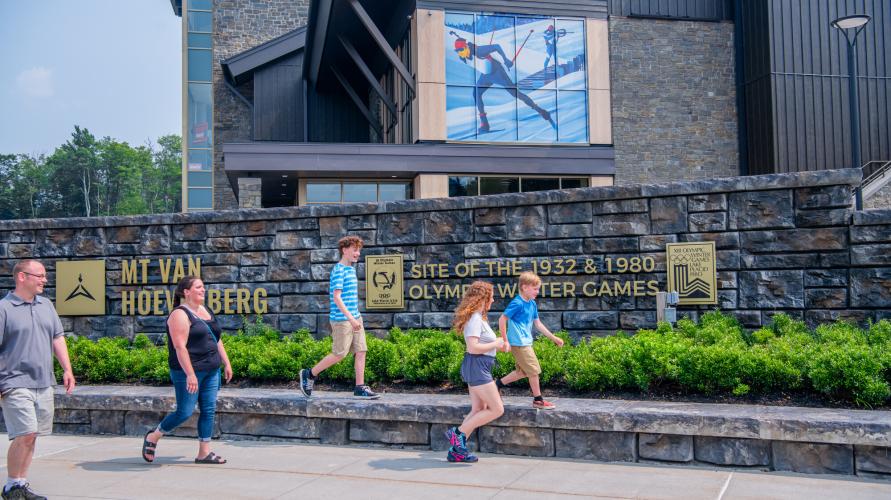 A family walks by a large mountain lodge