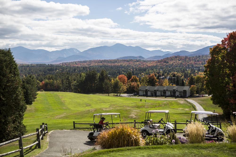 A man rides a golf cart along a path.