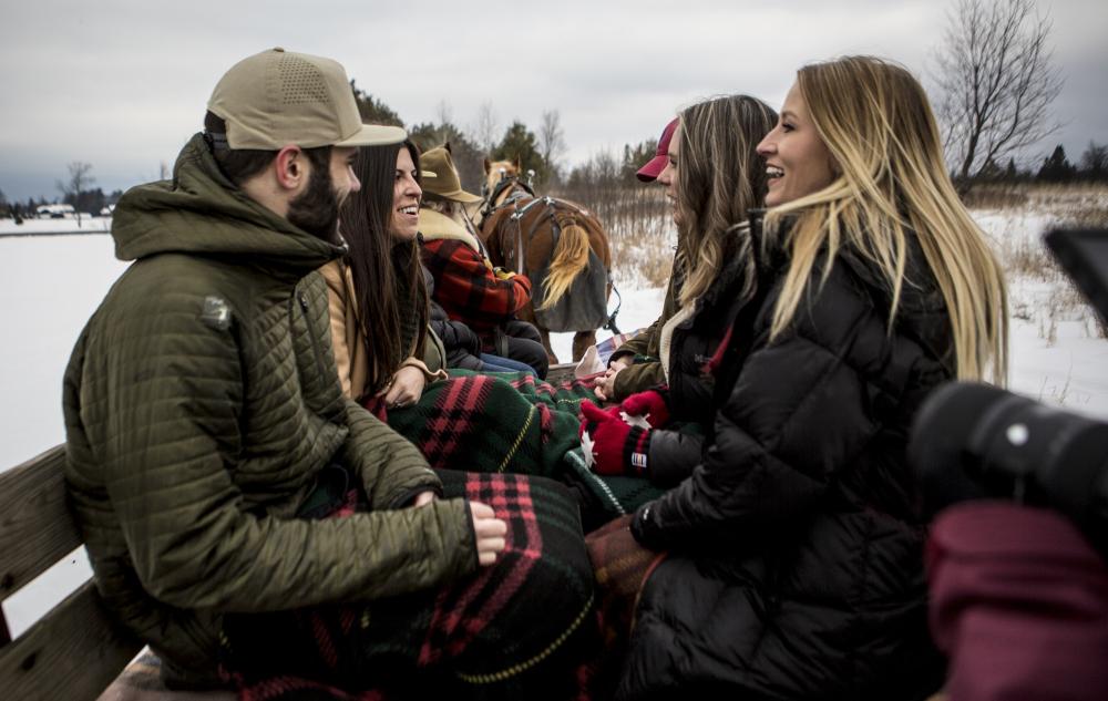 Group is cozy inside the wooden sleigh.