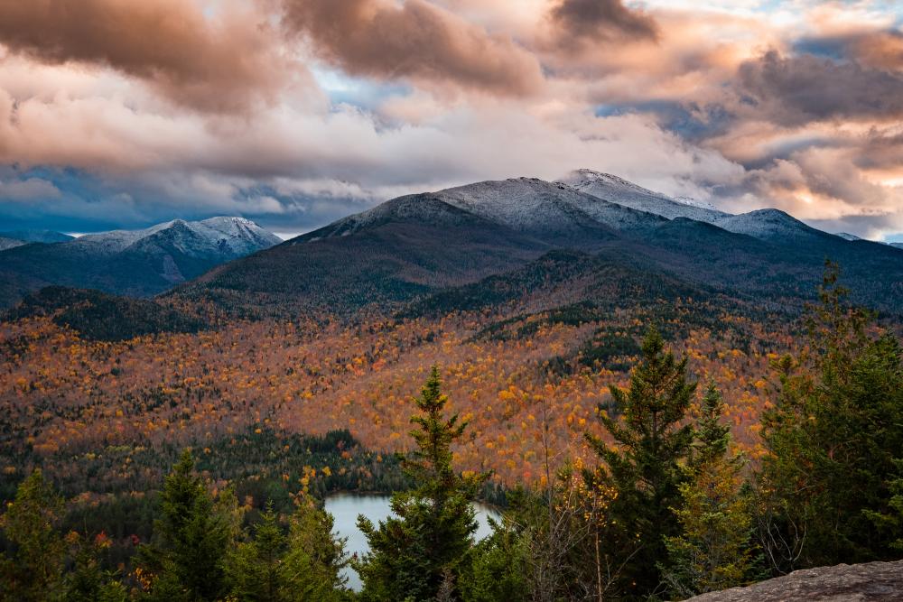 An aerial view of a fall mountain range with snow coming in.