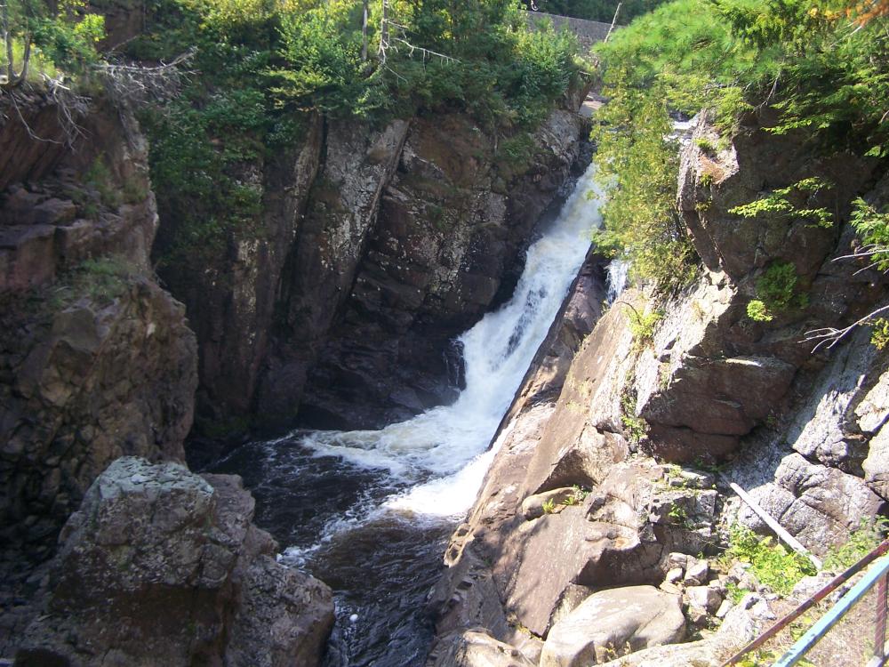 View of one of the waterfalls at High Falls Gorge from a suspended walkway above the Au Sable River.