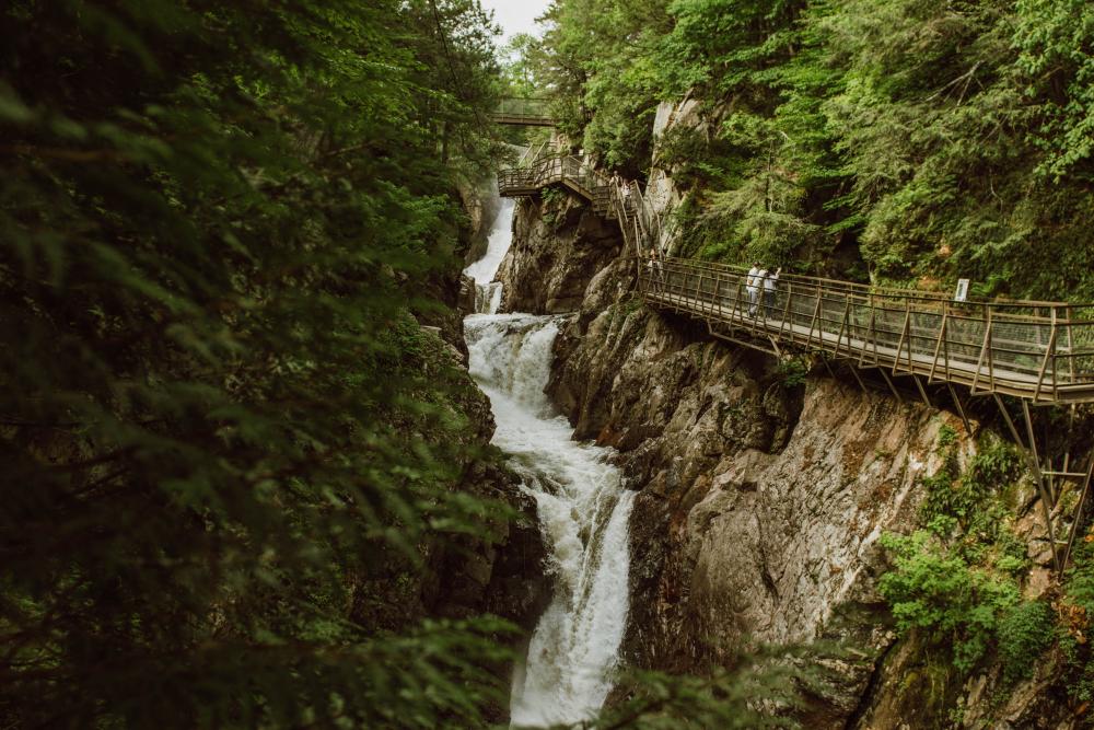 Suspended walkway hanging on the side of a cliff face above a series of waterfalls on the Au Sable River at High Falls Gorge