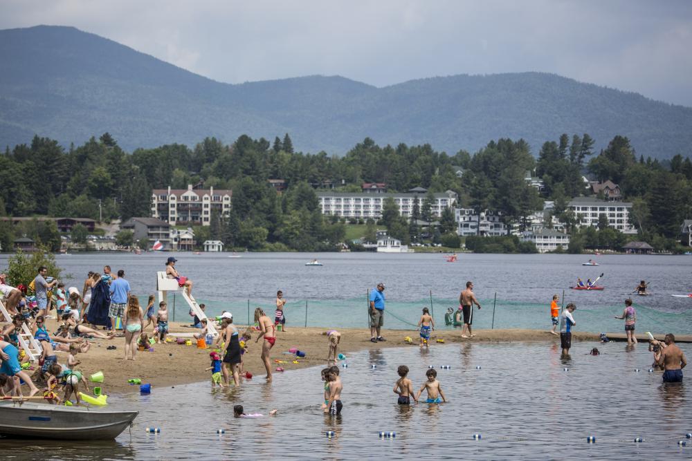 The public beach packed with people enjoying Mirror Lake