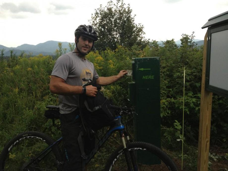 A rider making a donation in the box on the Lake Placid Club and Resort property