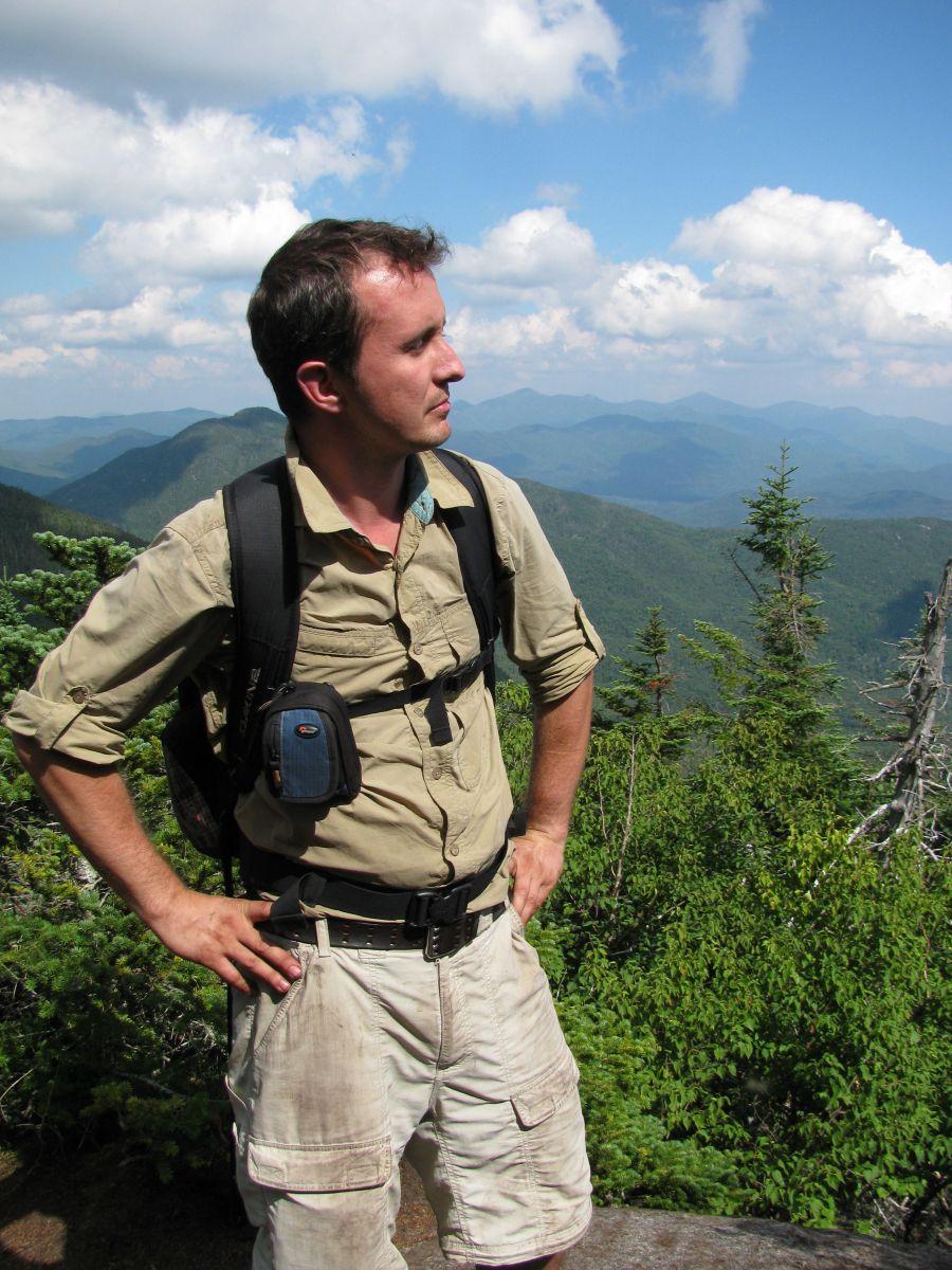 A man in beige clothes hiking in upstate ny