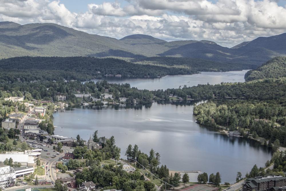 An aerial view of the village of Lake Placid, lined with shops and restaurants, and adjacent to Lake Placid lake and Mirror Lake. An aerial view of the village of Lake Placid, lined with shops and restaurants, and adjacent to Lake Placid lake and Mirror Lake.