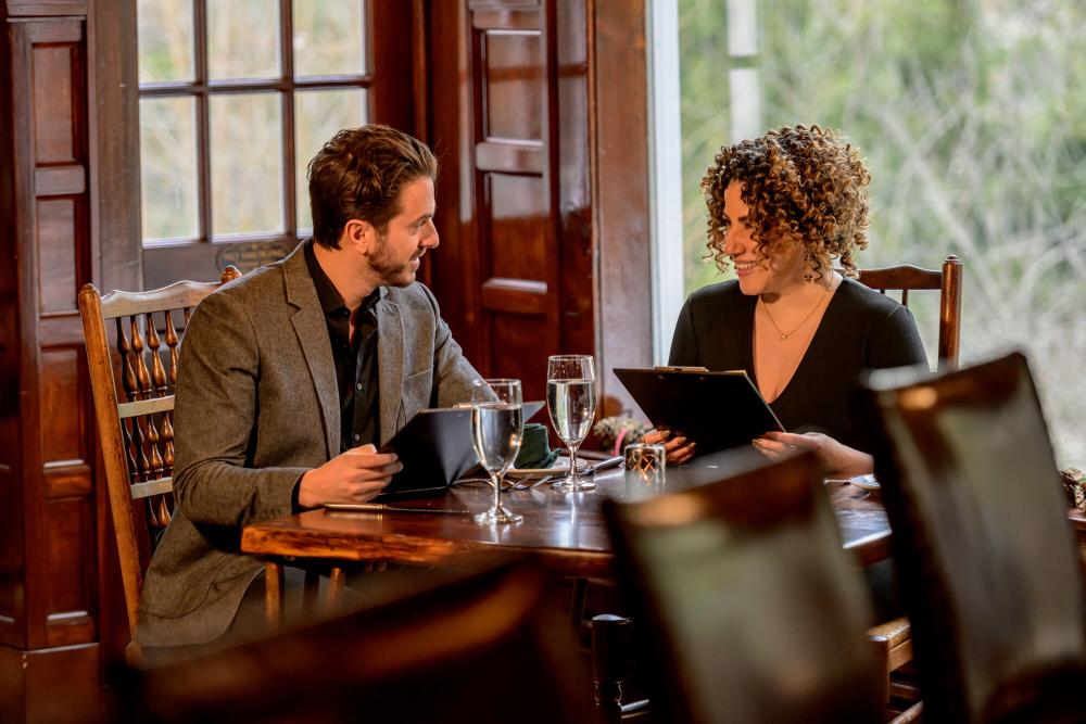 A man and woman look over menus in a lodge-style restaurant.