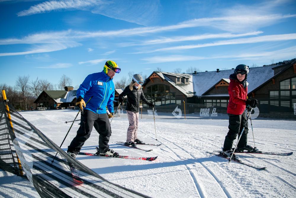 Two women taking a ski lesson with an instructor at Whiteface Mountain.