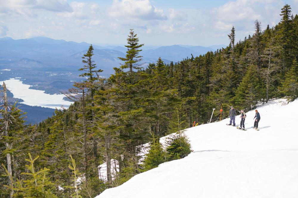 Skiers and snowboarders ready on a hill to ski and snowboard.