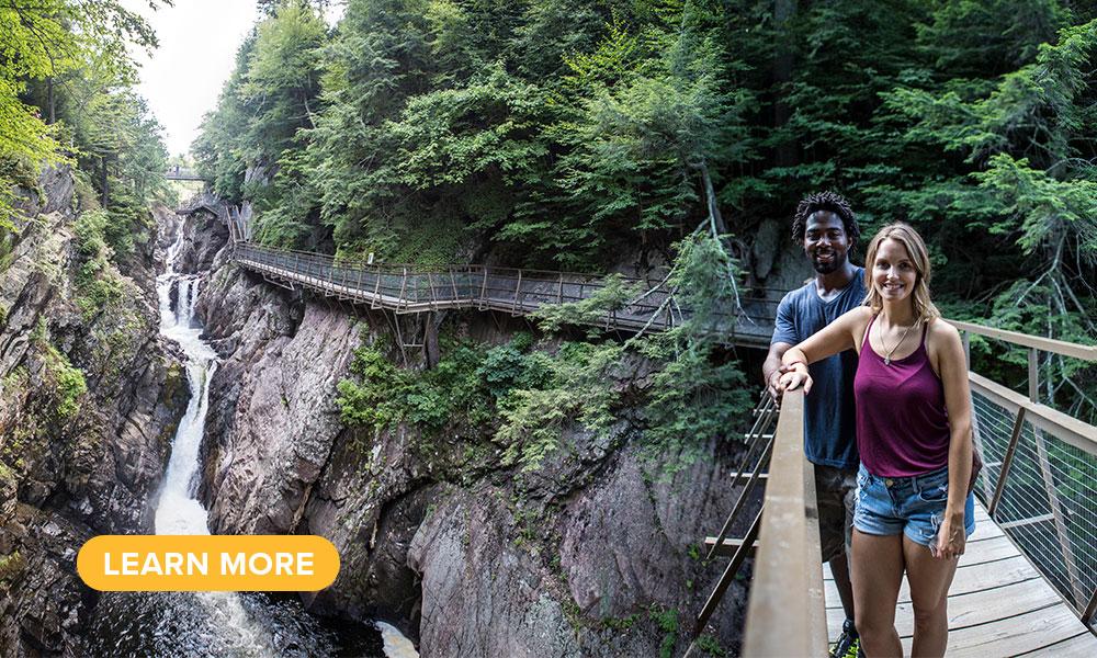 A couple poses on a footbridge crossing over High Falls Gorge.