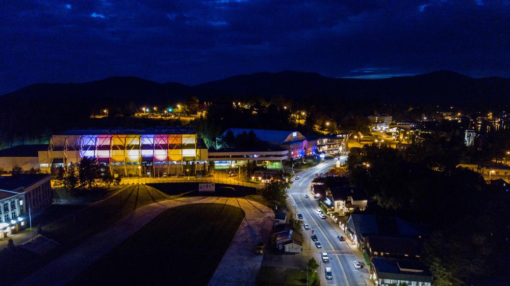 The Lake Placid Olympic Center buildings lit up at night.