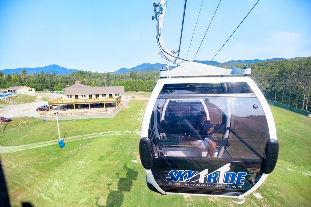 A glass gondola rises above the Intervales Lodge at the Olympic Jumping Complex.