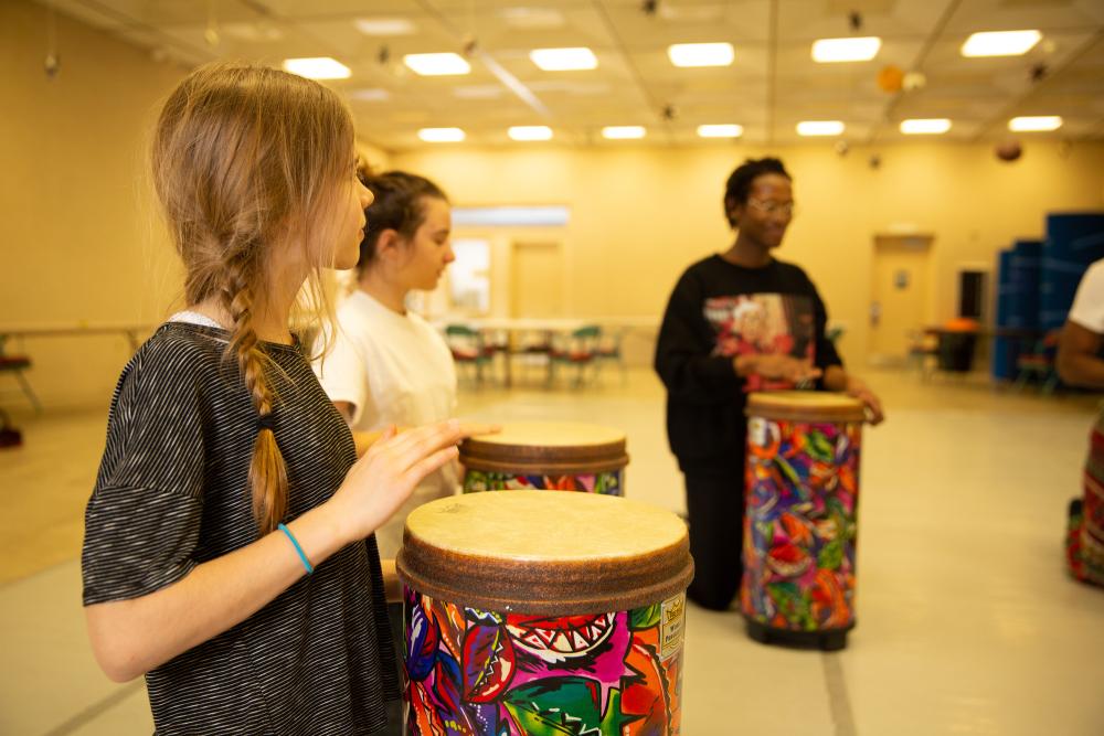 Three people in a bongo drum workshop.