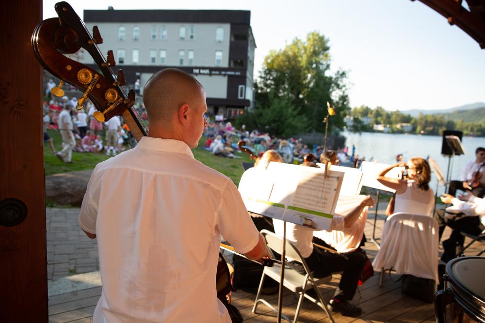 Orchestra musicians preforming with white shirts and black pants.