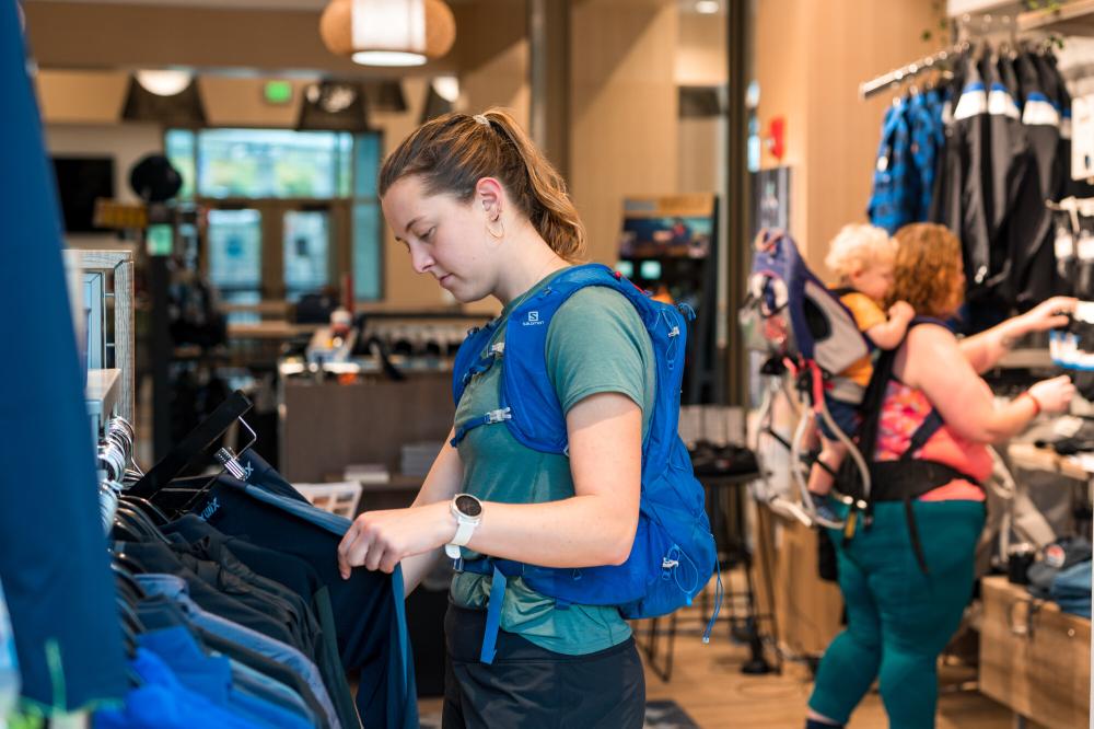 A woman shops at an outdoor gear shop.