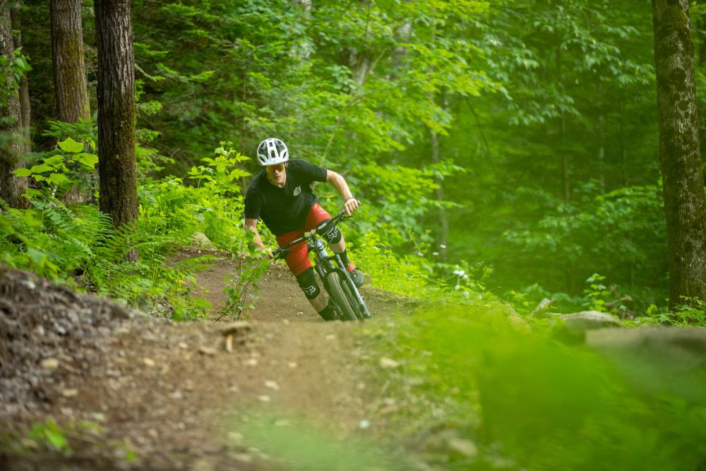 A man rides his mountain bike on a trail through the woods