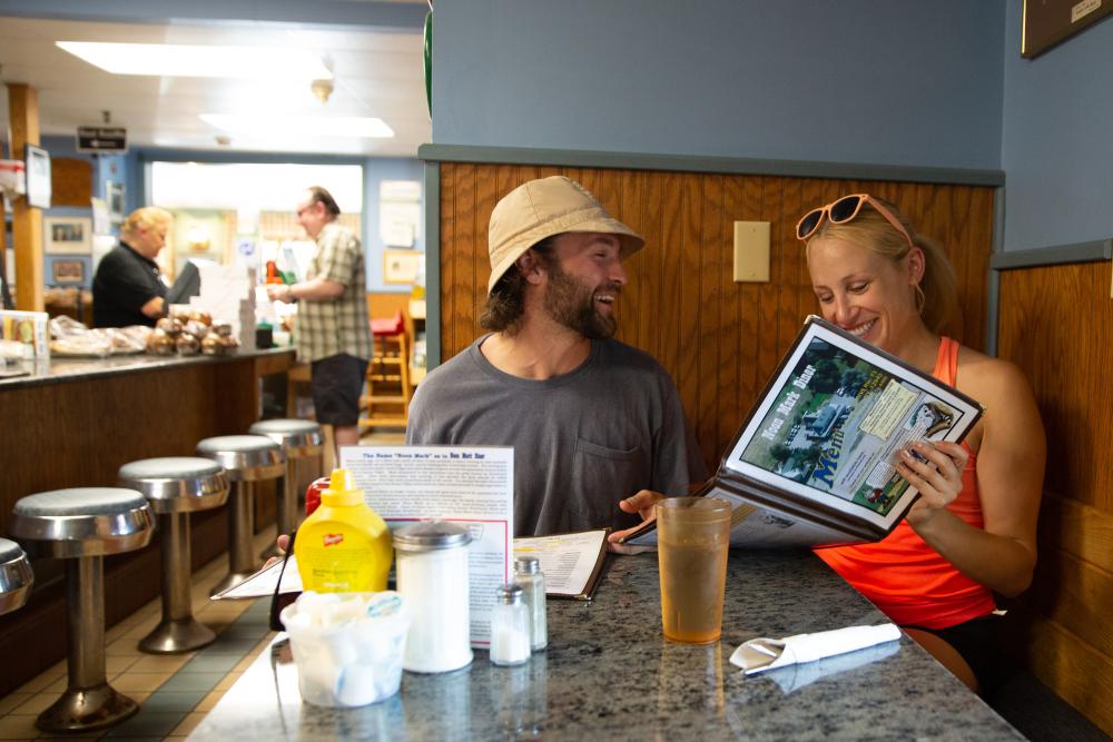 Two people look at diner menu