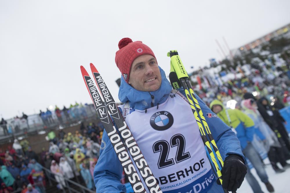 Tim Burke stands with skis and poles after race