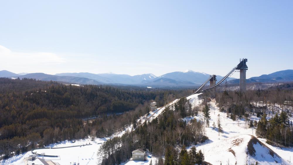 An aerial view of Olympic ski jumps with Adirondack Mountains beyond.