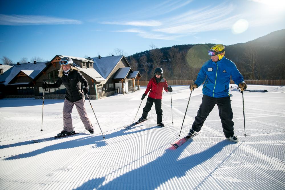 Two people are learning the basics from their ski instructor