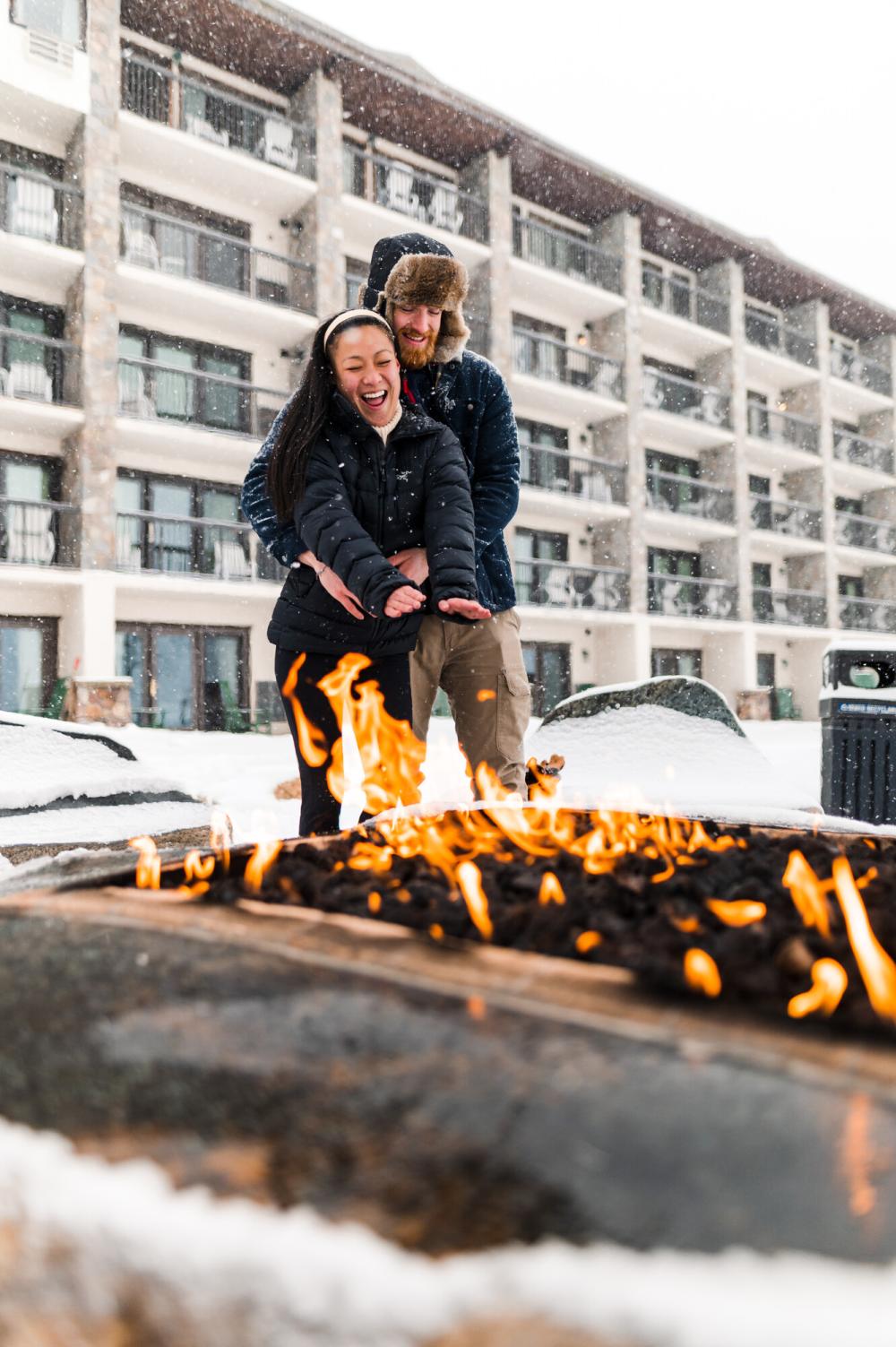 a couple gets cozy by a campfire.