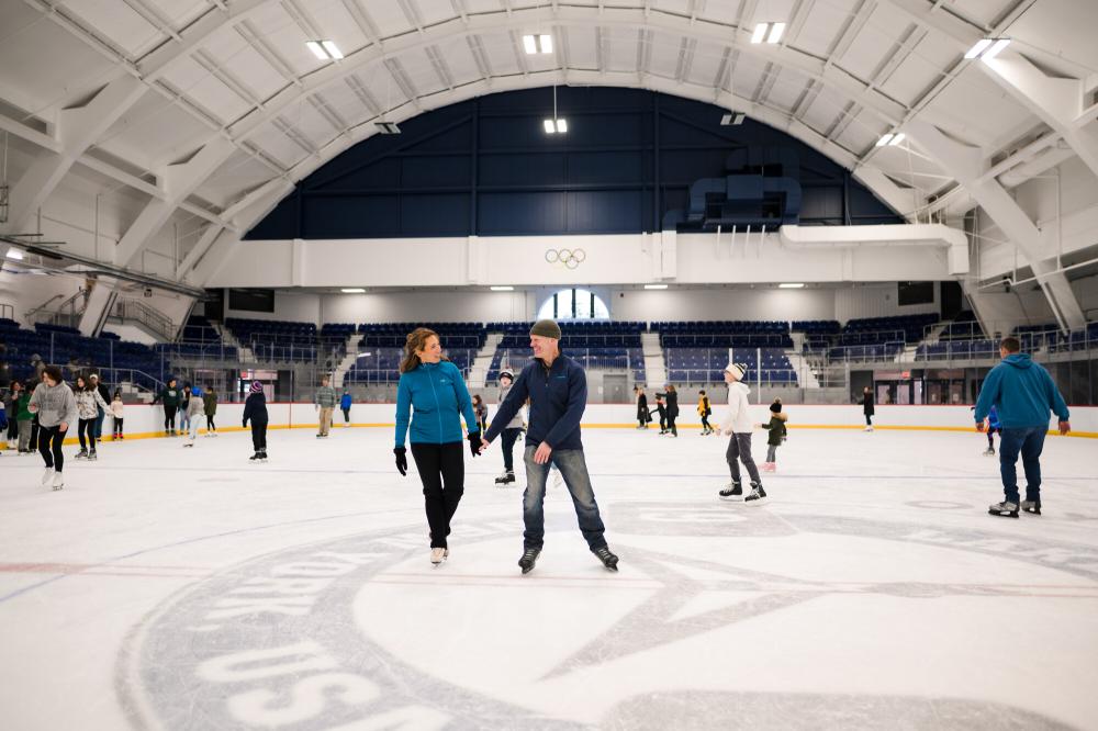 a couple skates in the middle of an ice skating rink.