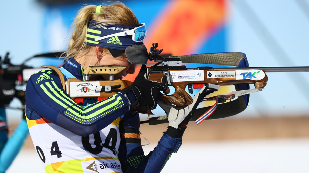 A female biathlete takes aim in a competition.