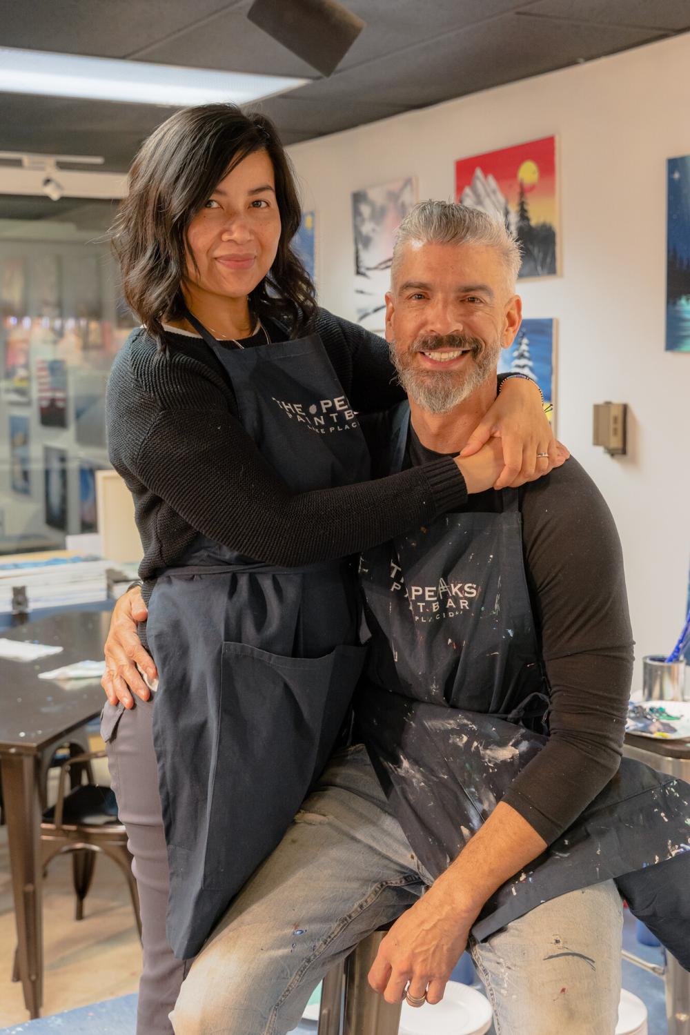 couple posing in front of their business