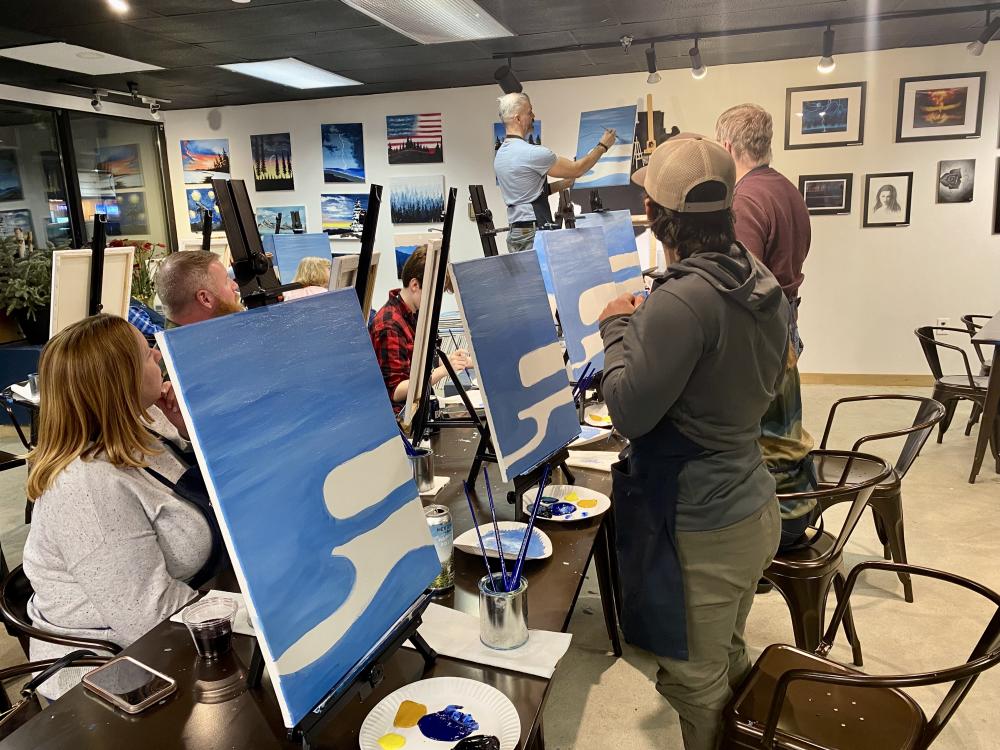 group painting the water on their canvases