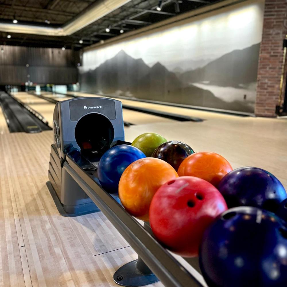 A bowling ball return full of colorful bowling balls