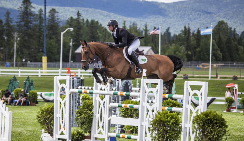 A horse jumps over a hurdle at the Lake Placid Horse Show grounds