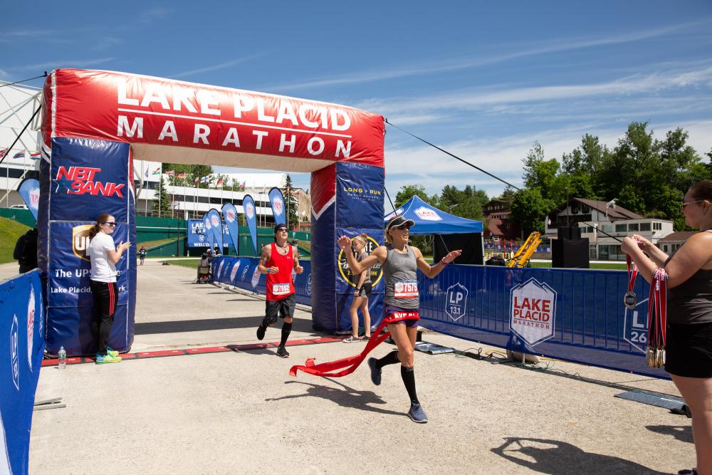 A runner crosses the finish line at Lake Placid Marathon and Half Marathon